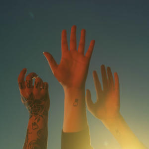 Cover art of boygenius' the record.
It depicts three raised hands.
Each arm is also tattooed with a tooth.
The left hand, belonging to Julien Baker, has a lot of other tattoos and shows the back of her hand.
The middle hand, belonging to Lucy Dacus, is showing the palm.
The right hand, belonging to Phoebe Bridgers, also shows the palm.
Phoebe also has a thin ring on her pink.