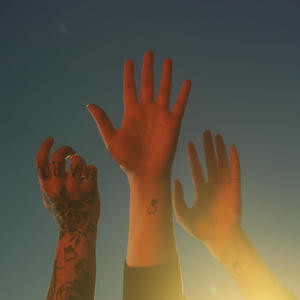 boygenius - the record Cover art of boygenius' the record.
It depicts three raised hands.
Each arm is also tattooed with a tooth.
The left hand, belonging to Julien Baker, has a lot of other tattoos and shows the back of her hand.
The middle hand, belonging to Lucy Dacus, is showing the palm.
The right hand, belonging to Phoebe Bridgers, also shows the palm.
Phoebe also has a thin ring on her pink.
